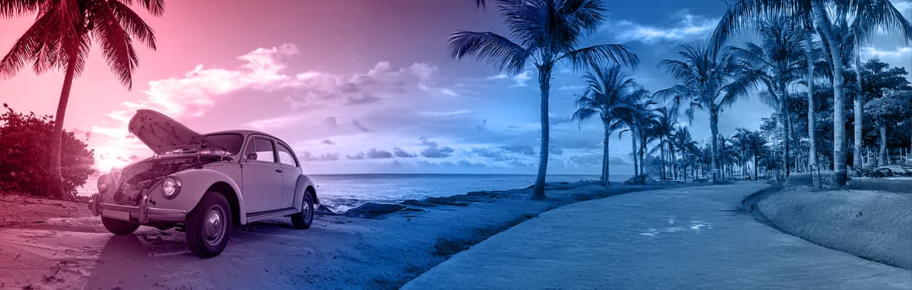 海沿いに駐車されたボンネットの開いたクラシックカー