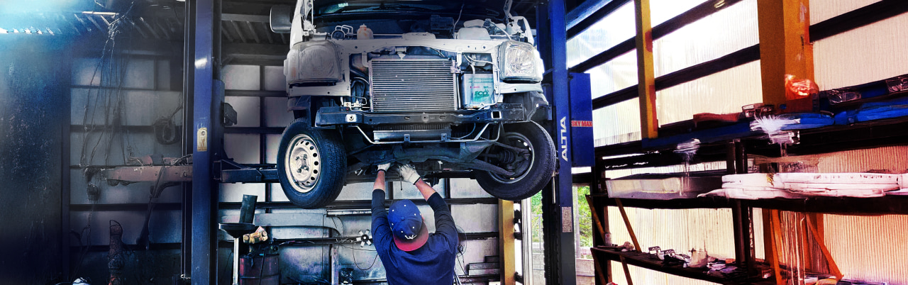 整備士が車をリフトアップして点検している風景