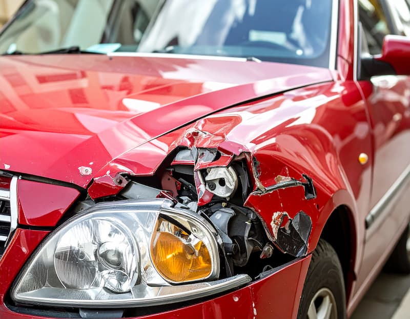 交通事故で損傷した赤い車のフロント部分